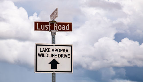 Low angle view of road sign against sky