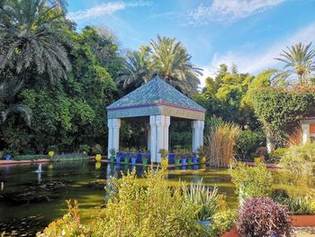 Gazebo by lake against sky