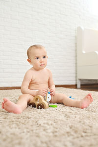 Portrait of cute baby boy sitting on floor