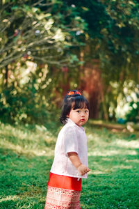 Rear view of young woman standing on field