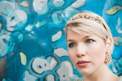 Close-up of thoughtful woman against patterned wall