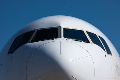 Close-up of airplane against clear blue sky