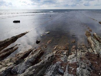 Surface level of sandy beach against sky