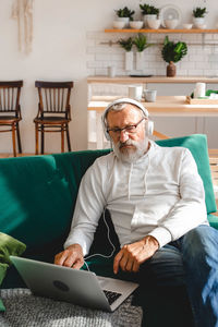 Portrait of senior man using laptop at home