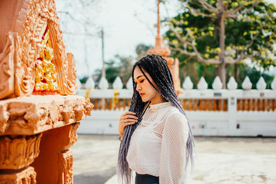 Side view of young woman standing outdoors