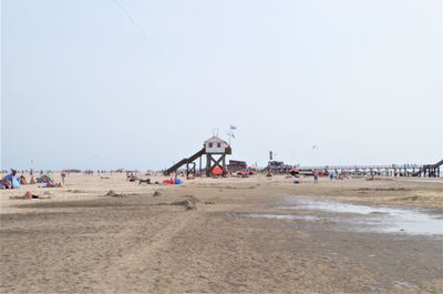 People on beach against clear sky