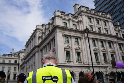 Rear view of people against buildings in city