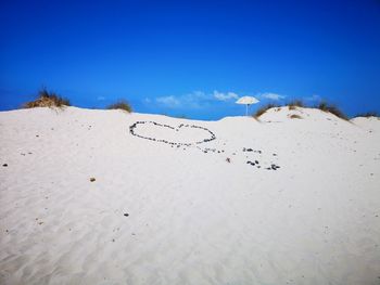 Scenic view of beach against clear blue sky