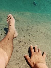 Midsection of man hand on sand at beach