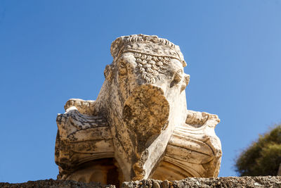 Low angle view of statue against blue sky