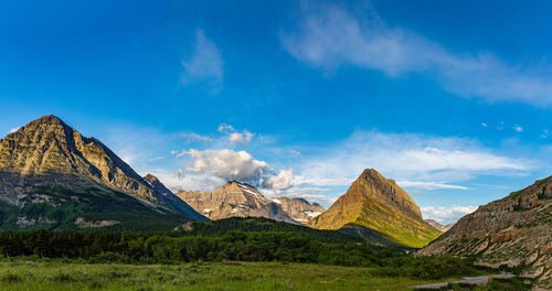 Panoramic view of landscape and mountains against blue sky