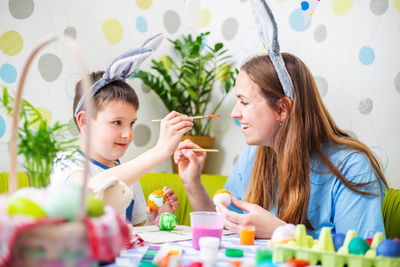 Portrait of young woman applying make-up to daughter at home