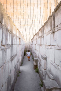 Rear view of people walking on wall