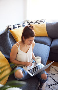 Woman sitting on sofa at home