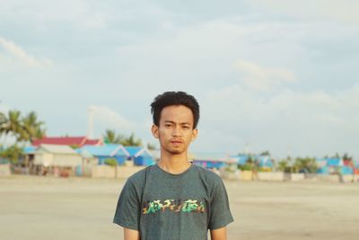Portrait of young man standing on beach