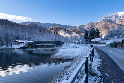 Road by snowcapped mountains against sky