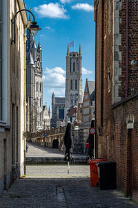 Man walking on street amidst buildings in city