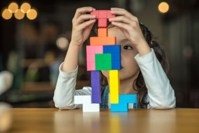 Close-up of girl playing with toy blocks on table