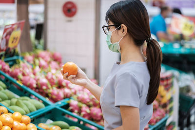 Midsection of woman holding ice cream at market