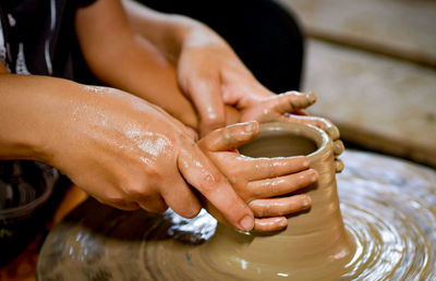 Close-up of cropped hands doing pottery