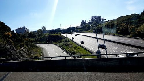 Road by bridge against sky in city