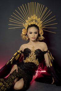 Portrait of young woman sitting on sofa at home