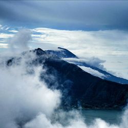 Scenic view of mountains against cloudy sky