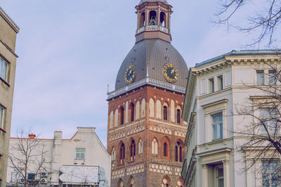 Low angle view of clock tower amidst buildings in city