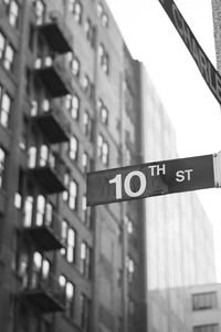 Low angle view of road sign against building