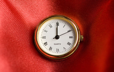 Close-up of clock on red fabric