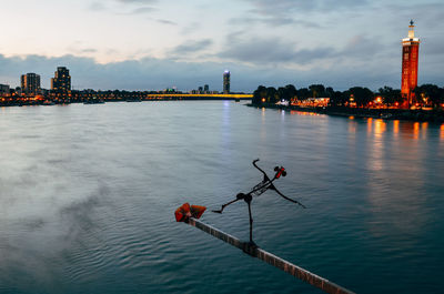 Sculpture over rhine river in city against sky