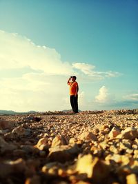 Surface level of man standing on sand against sky