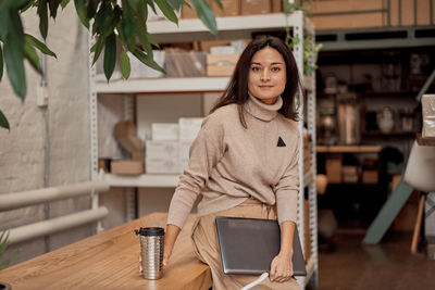 Portrait of young woman standing in cafe