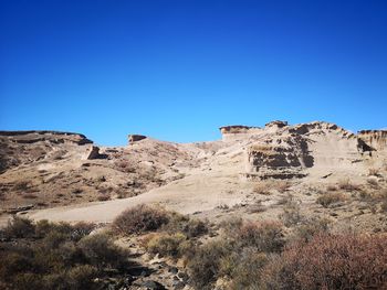 Scenic view of rocky mountains against clear blue sky