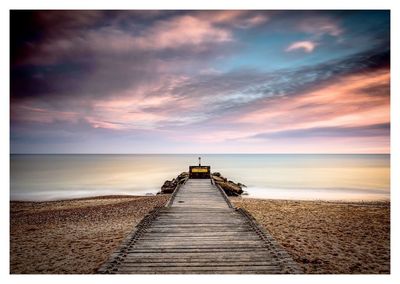 Boardwalk on beach against sky