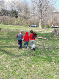 Rear view of people walking on field