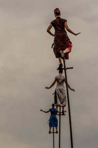 Low angle view of people working against sky