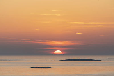 Scenic view of sea against orange sky