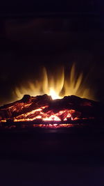 Campfire on mountain against sky at night