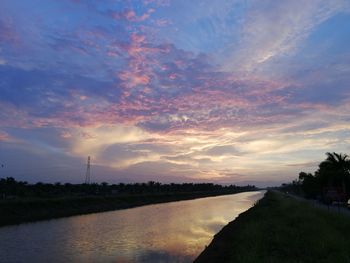 Scenic view of river against sky at sunset