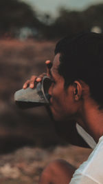 Side view of man drinking juice