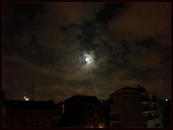 Low angle view of illuminated building against cloudy sky