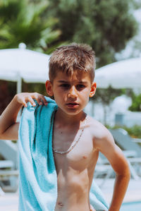 Portrait of shirtless boy standing outdoors