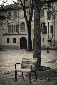 Empty chairs and tables in park against building