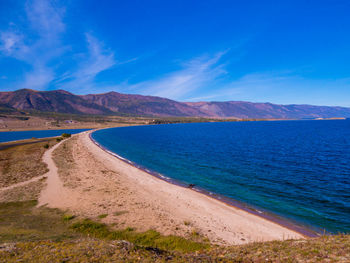 Scenic view of beach against blue sky