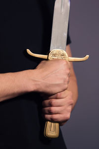 Close-up of hand holding hands against black background