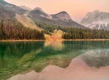 Scenic view of lake by mountains against sky