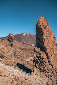 Rock formations on mountain against clear blue sky