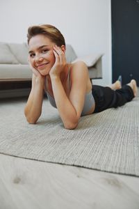 Portrait of young woman sitting on floor