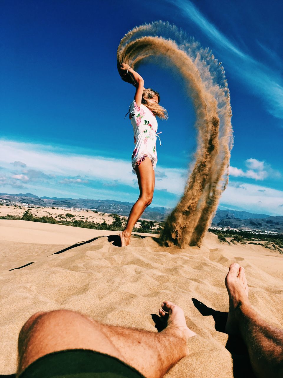 YOUNG WOMAN JUMPING ON BEACH